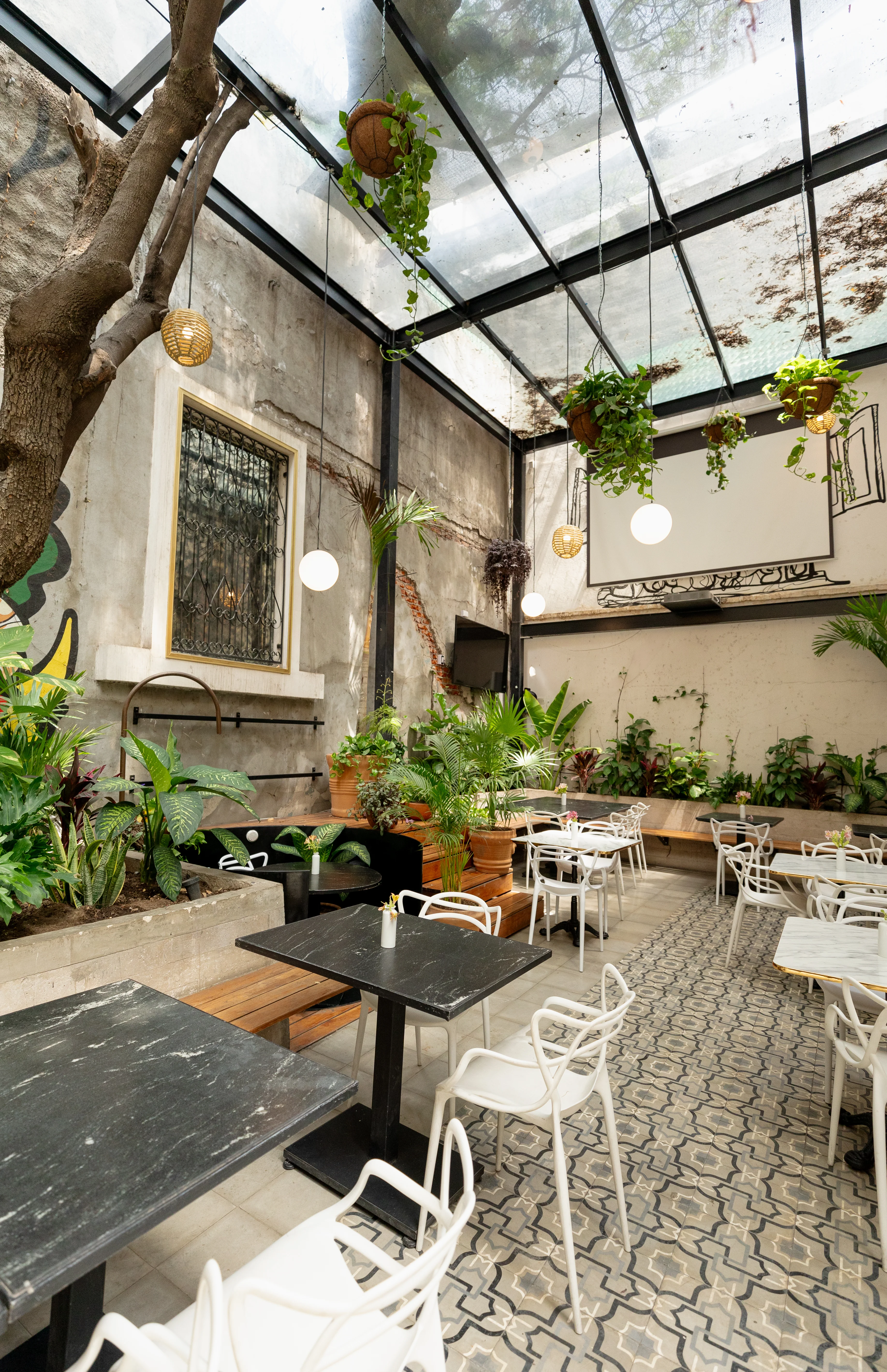 Jardín interior de Tosta con terraza y techo de cristal